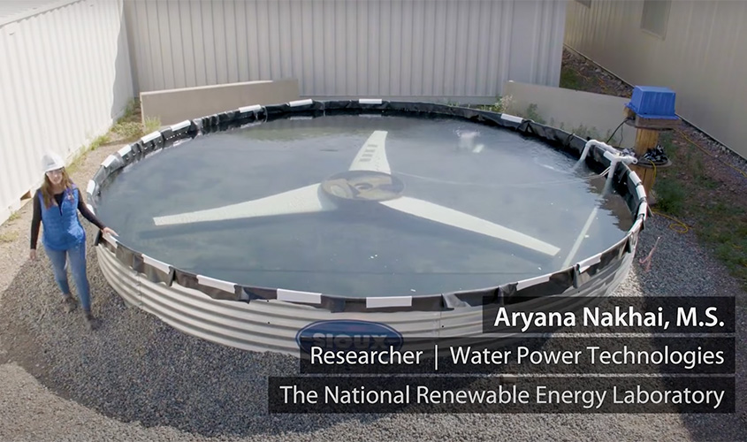 Aryana Nakahi walks around a circular water tank with a three-bladed turbine inside overlain with her name and title.