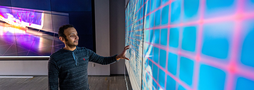Hari Sitaraman projects some of his research diagrams and graphics onto screens in the Insight Center Visualization Lab in the Energy Systems Integration Facility.