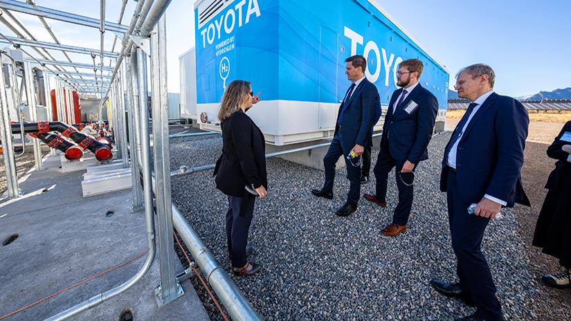 Jen Kurtz stands and points to large data storage system in front of group of professionals out in the field