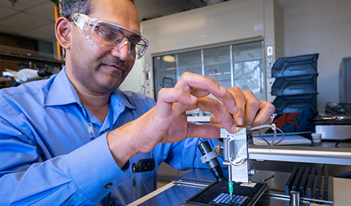 Sreekant Narumanchi positions and places a semiconductor device on a power electronics package.