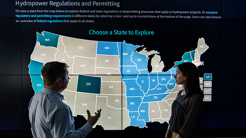 Two people in front of an interactive U.S. map