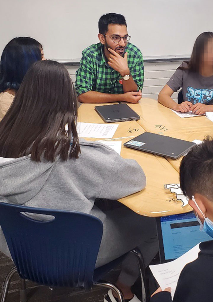 Adult and students gathered around a table.