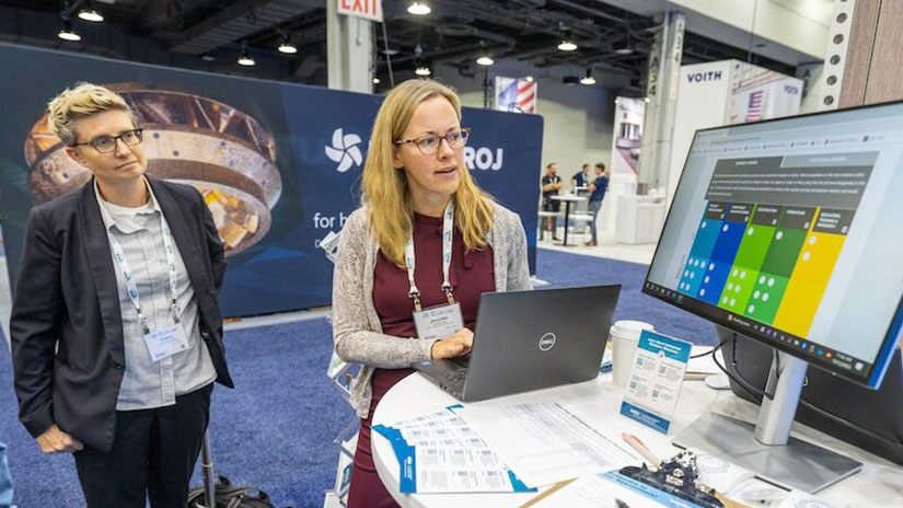 Two people look at computer during conference