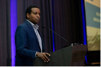 Congressman Joe Neguse speaks at a podium.