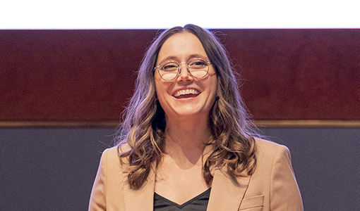 A woman stands on stage, smiling. 