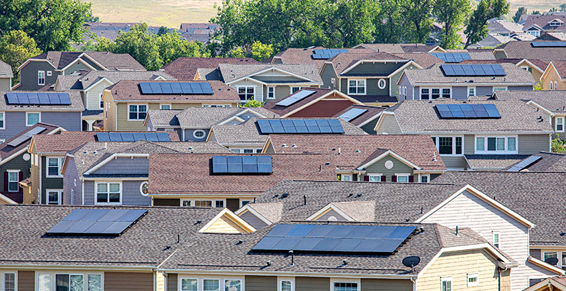 Photo of a neighborhood of single-family homes with solar panels installed on each.