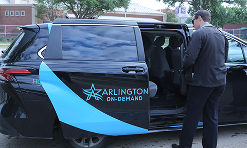 A man steps into a black Arlington On-Demand rideshare shuttle