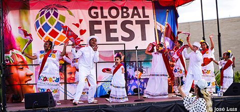 A group on a stage with a Global Fest banner in the background.