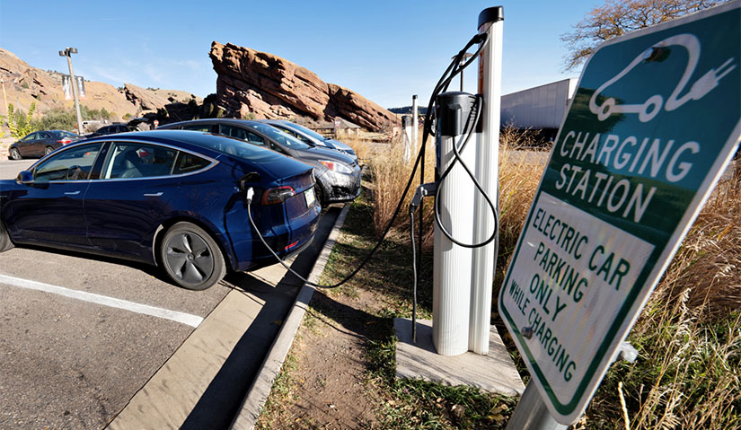 A photo of an electric vehicle plugged into a charging station.