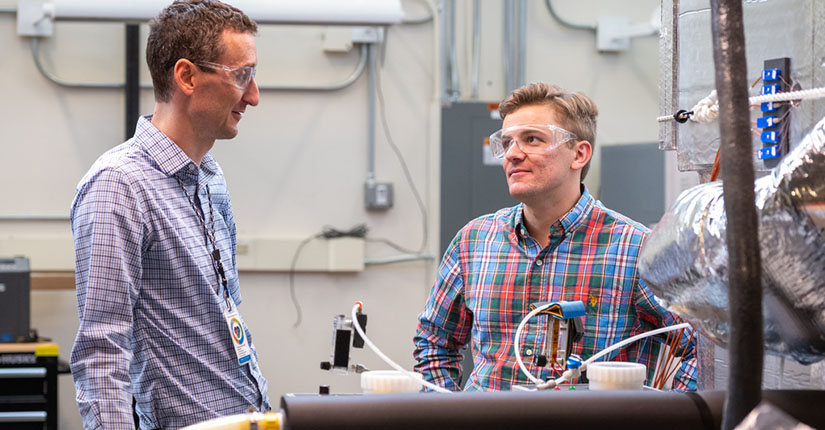 Two men looking at each other in a laboratory. 