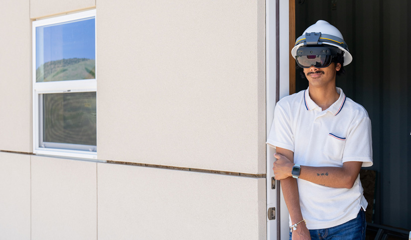 A man wearing protective headgear standing in a doorway.