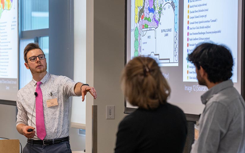 A man presenting with two people watching.