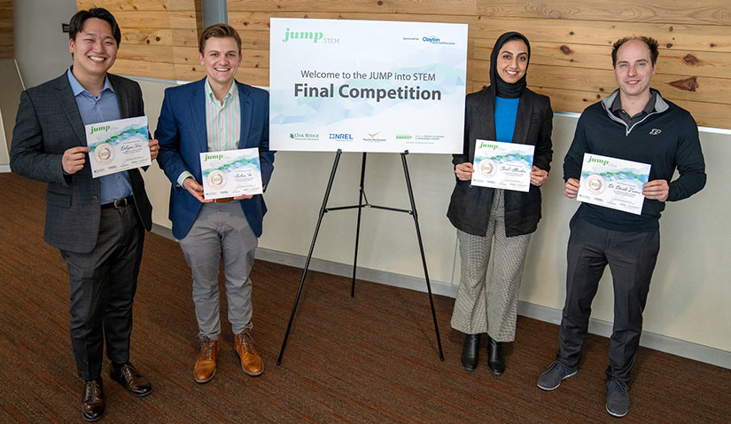 Four researchers holding certificates.