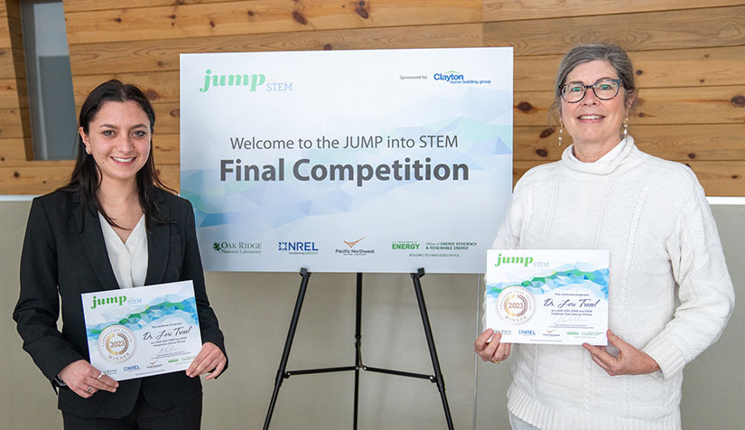 Two researchers holding certificates. 