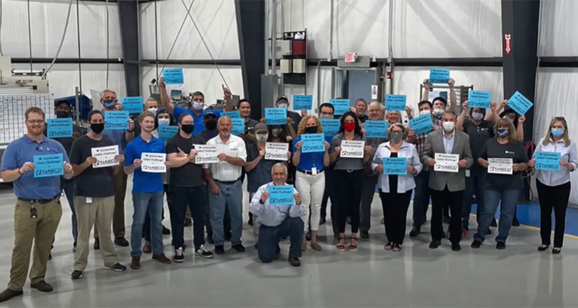 A group of people in a lab holding up signs.