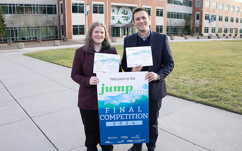 Two people standing outside and holding certificates. 
