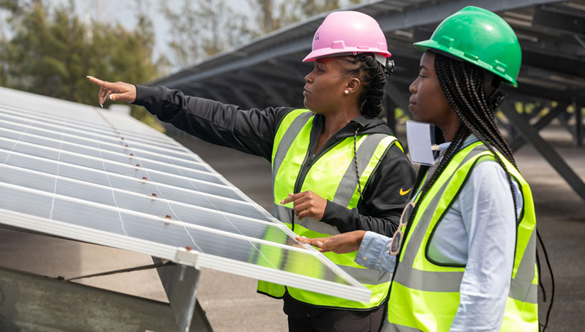Two people working on a solar panel system