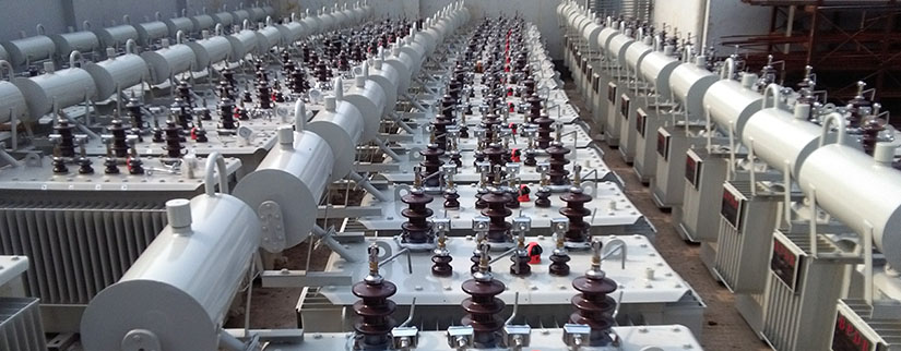 A large room containing rows of distribution transformers.