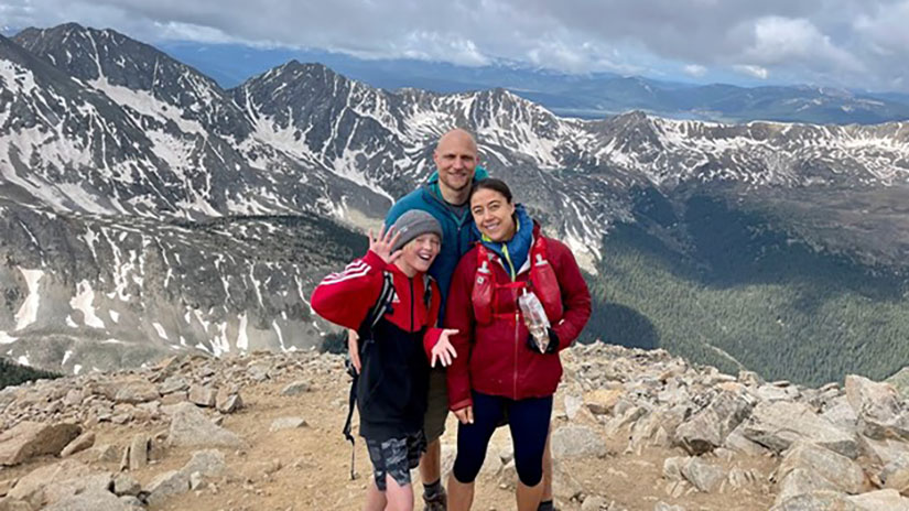 Travis Lowder with family hiking on mountain