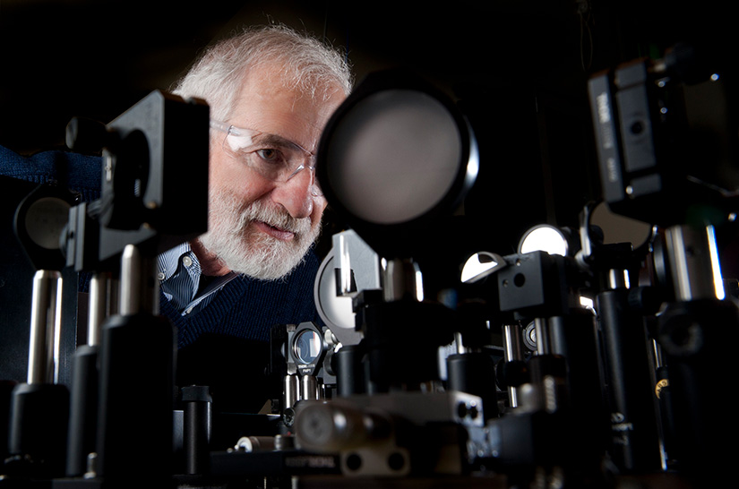 A man surrounded by laser mirrors in a lab