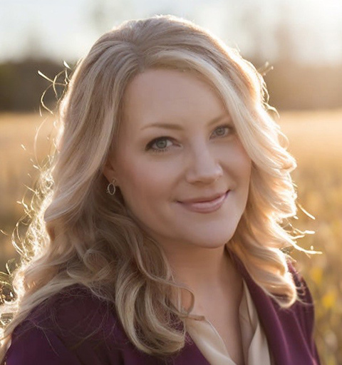 A woman smiling at sunset.