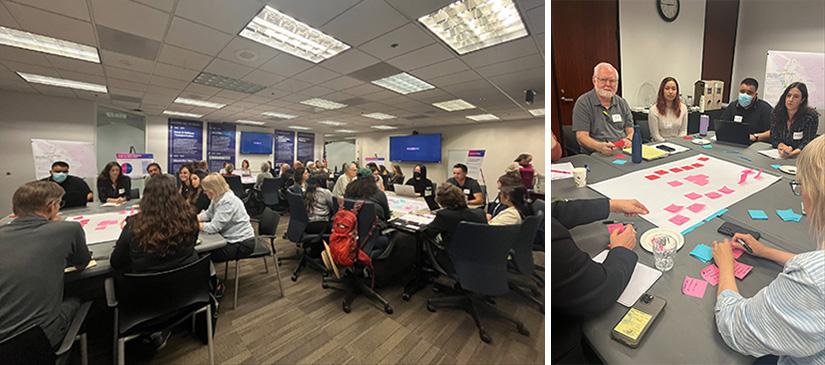 A photo of people sitting around tables in a conference room.