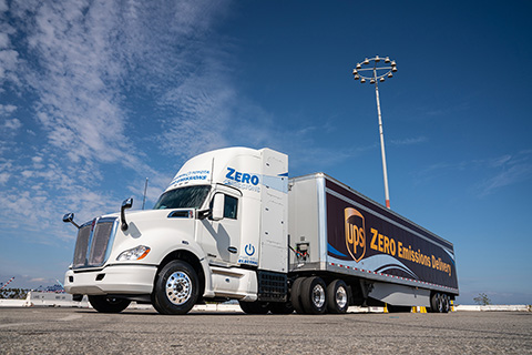 A hydrogen fuel cell truck with an advertisement reading "UPS Zero Emissions Delivery" against a bright blue sky.