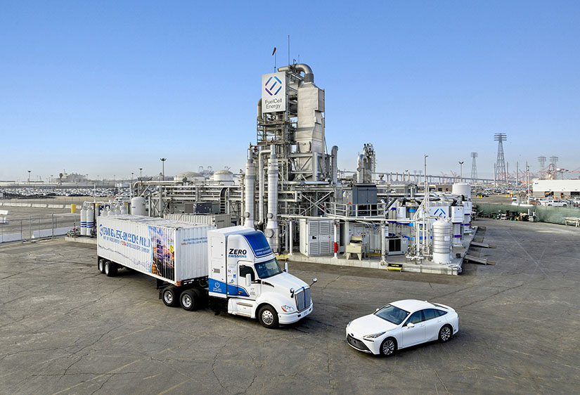 Hydrogen-powered trucks and passenger cars parked outside of Toyota Logistics Services at the Port of Long Beach.