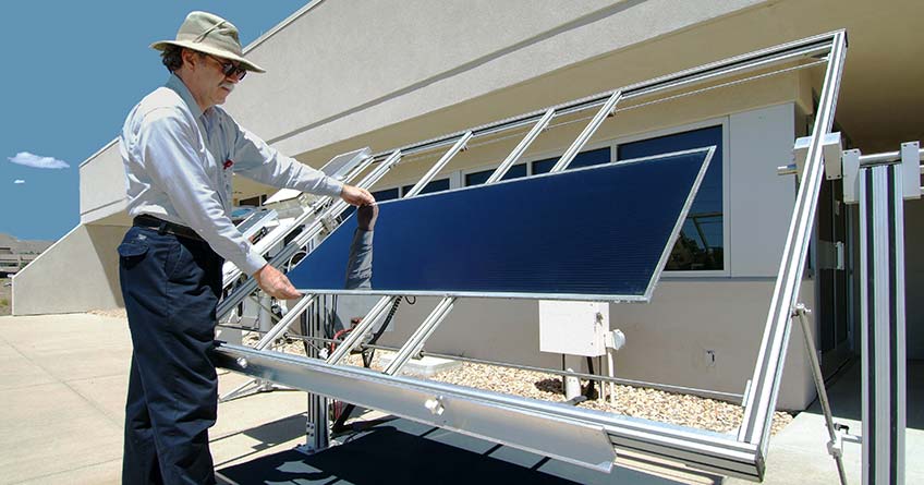 A researcher places a solar cell on an outdoor rack. 
