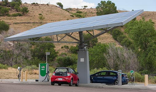 Two electric vehicles parked under a PV canopy.