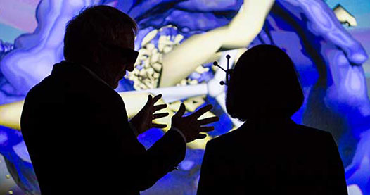 A man and woman talking in front of a 3D visualization