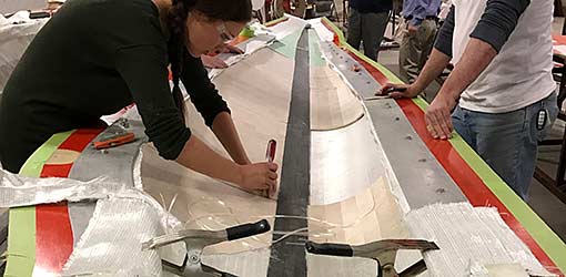 Composite manufacturing technicians work on a wind turbine blade mold at the Composites Manufacturing Education and Technology facility (CoMET).