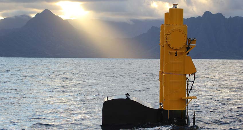 A large buoy in the ocean near a coastline featuring tall mountains.