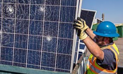 A worker with a damaged solar panel. 