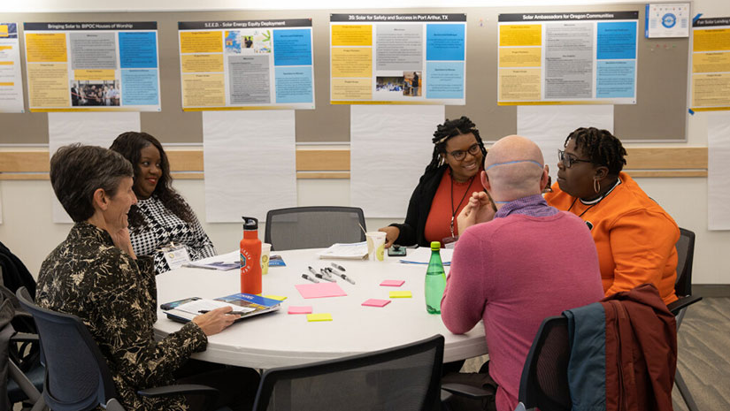 A group of Solar Energy Innovation Network participants collaborate around a table.