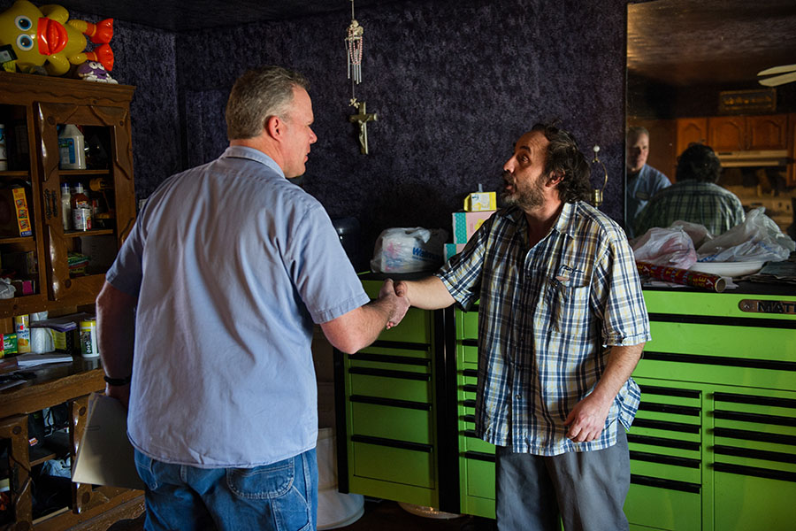 A weatherization professional shakes hands with a homeowner.