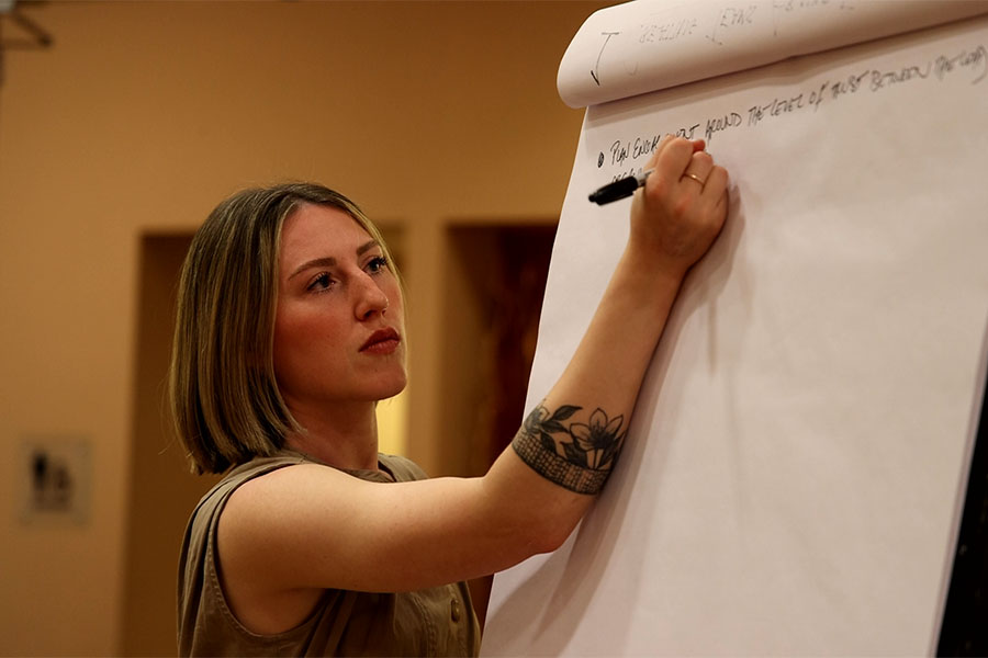 A photo of an NREL researcher writing on a whiteboard.