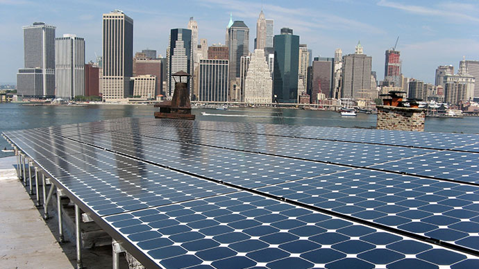 Image of solar panels in front of a cityscape.