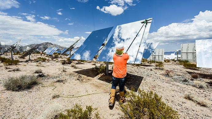 A worker cleaning a heliostat's mirror