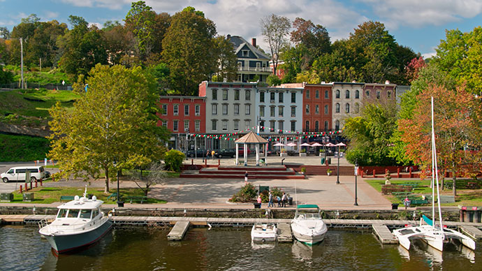 A photo of a historic building and trees near a dock in Kingston, New York.