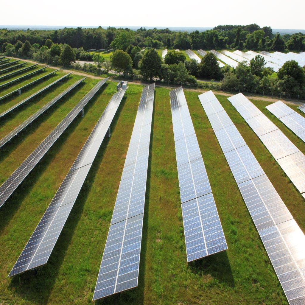 A photo of a large field covered with a large solar panel array.