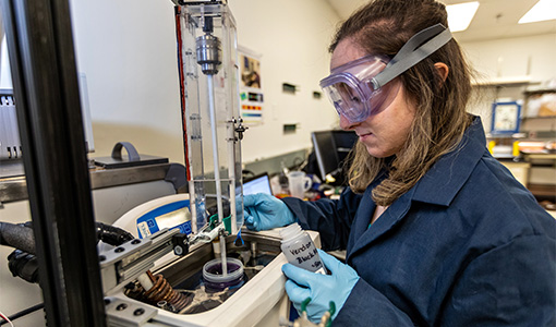 A researcher tests electrochemical materials in a laboratory.