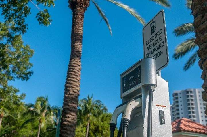 Level 2 electric vehicle supply equipment in front of a palm tree in California