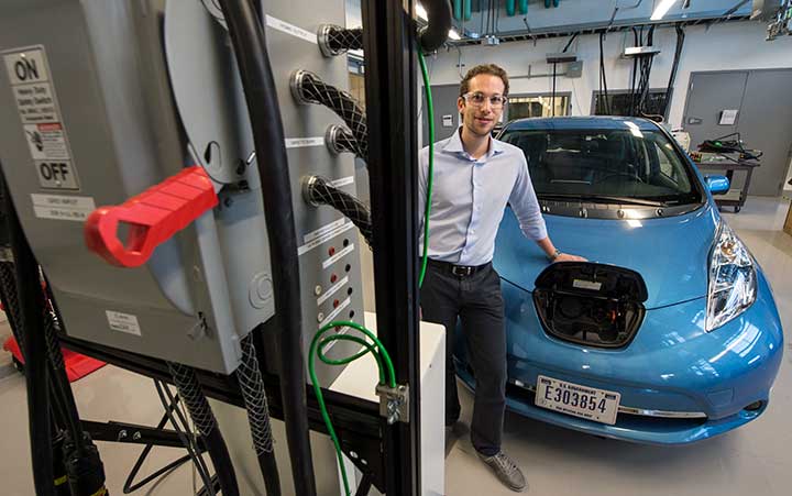 An engineer charges an electric vehicle in the Power Systems Lab in the Energy Systems Integration Facility at NREL.