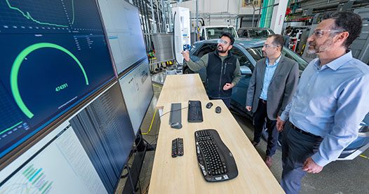 Three researchers looking at computer screens.