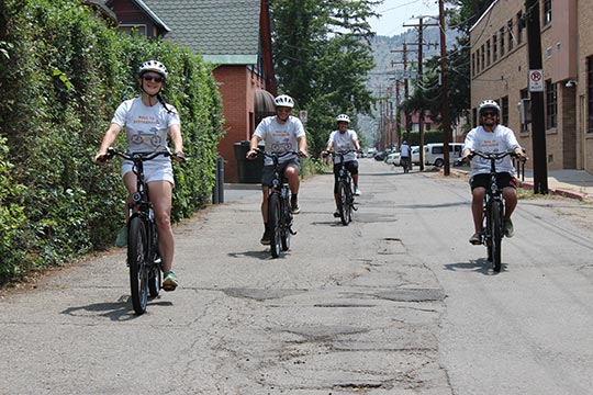 People riding e-bikes on a street.