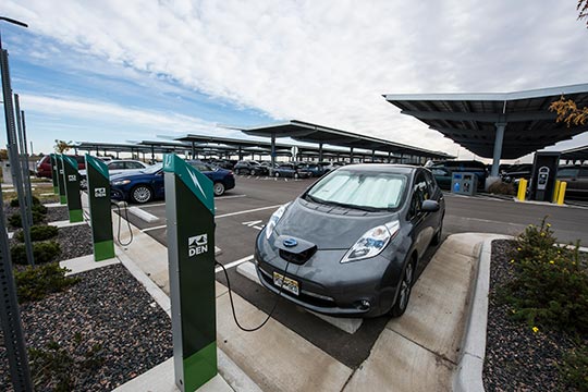 An electric vehicle charging at a public charging station.