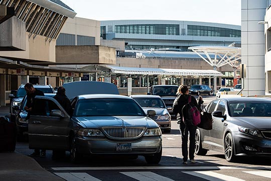 Cars moving through the passenger pickup area of an airport