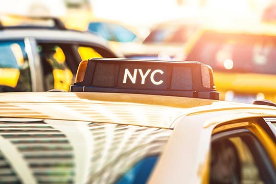 A New York City cab sitting in traffic.
