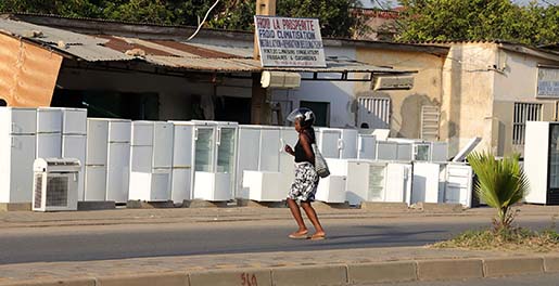 A woman walking across a street with a helmet on in Uganda.